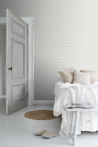 Helles Schlafzimmer mit gemusterter Tapete, Bett und offener Tür