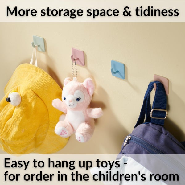 Selbstklebende Wandhaken zur Aufbewahrung im Kinderzimmer, abgebildet mit Hut, Stofftier und Rucksack.