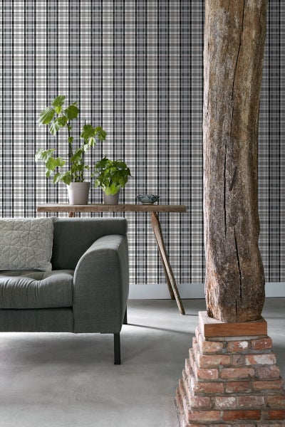 Raumansicht mit karierter Tapete, Sessel, Beistelltisch und Stehlampe