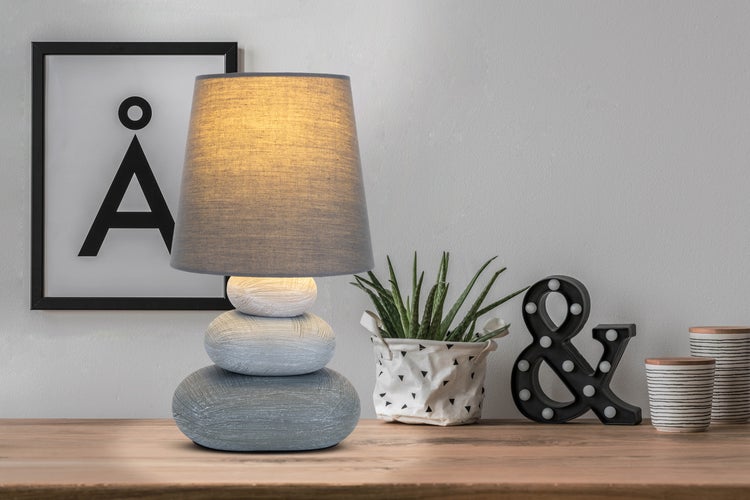 Dekorative Tischlampe mit Stoffschirm auf Holzoberfläche