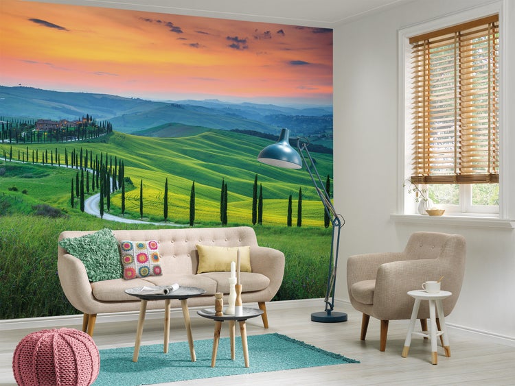 Modernes Wohnzimmer mit einer großflächigen Fototapete einer toskanischen Landschaft mit sanften Hügeln und Sonnenuntergang.