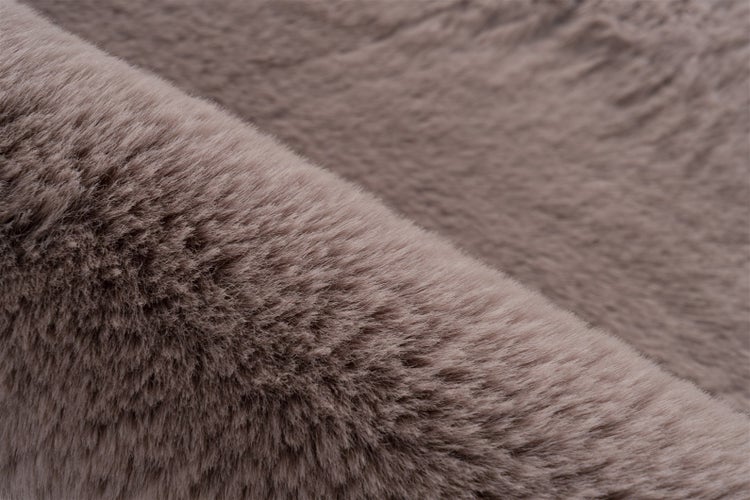 Nahaufnahme eines weichen Kunstfells in Taupe mit dichter, plüschiger Textur.
