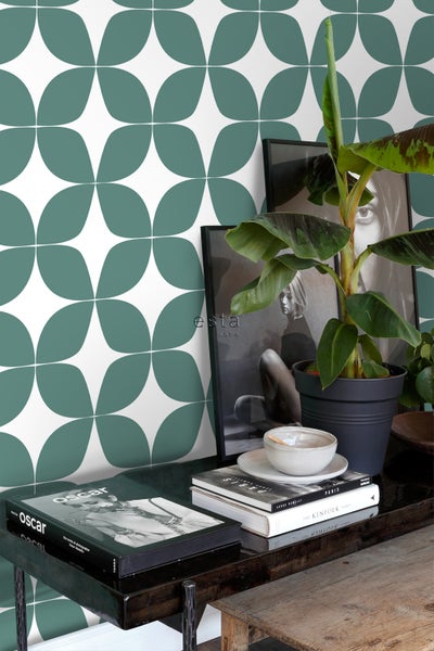 Wand mit Retro-Muster, dekoriert mit Pflanzen, Büchern und Bilderrahmen