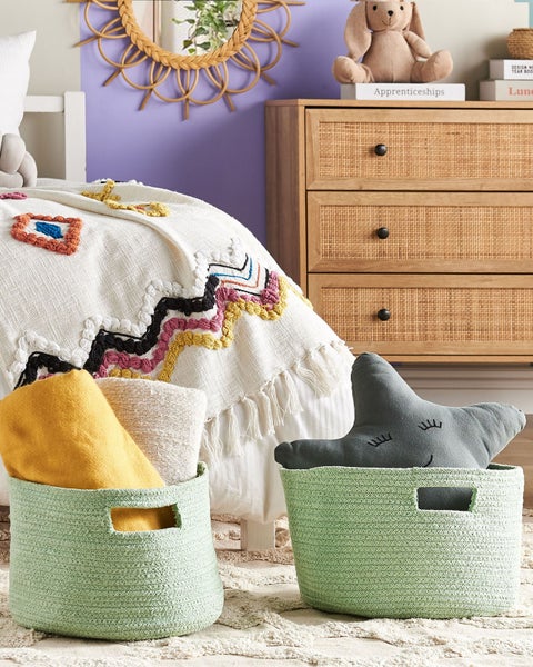 Dekoratives Kinderzimmer mit Bett, Kommode und zwei geflochtenen Körben