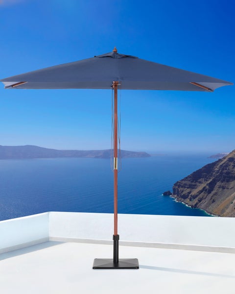 Quadratischer Sonnenschirm mit Holzstock, blauem Textilbezug und schwarzem Standfuß.