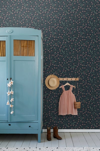 Kinderzimmer mit Tapete mit floralem Muster, blauem Schrank, Kleid und Accessoires.