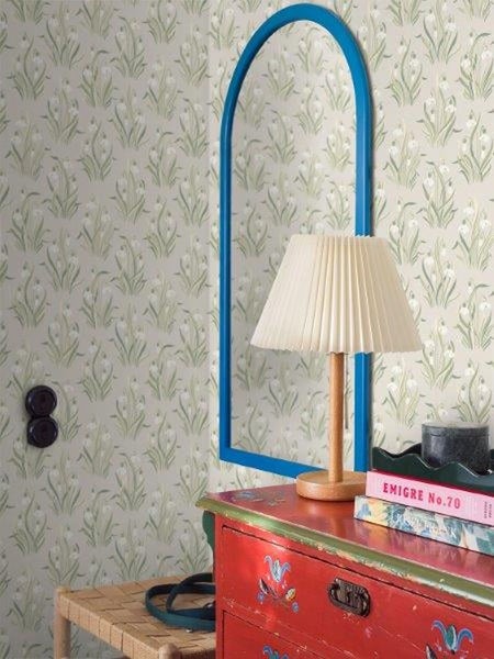 Dekorative Zimmeransicht mit Blumentapete, Spiegel, Lampe und Kommode