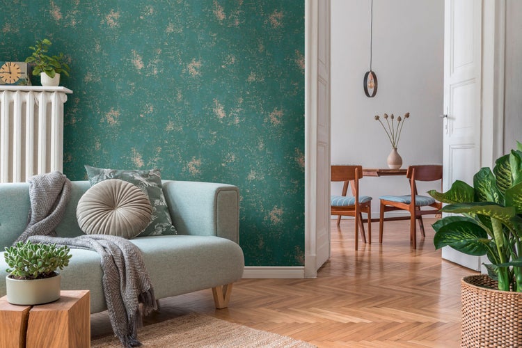 Wohnzimmer mit türkisfarbener Couch, gemusterter Tapete und Holzboden.