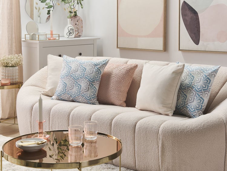 Wohnzimmer mit Sofa, Kissen und Beistelltisch