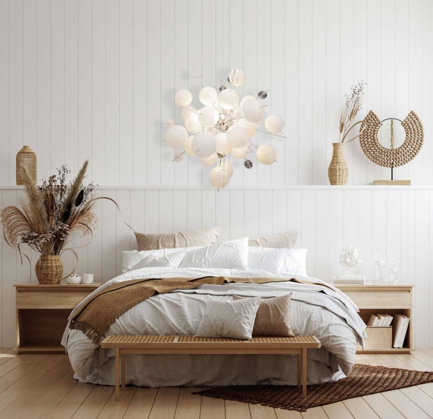 Helles Schlafzimmer mit Doppelbett, Nachttischen und dekorativer Beleuchtung für eine entspannte Atmosphäre.