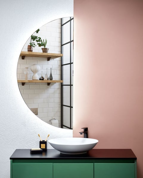 Badezimmer mit rundem Spiegel, Waschtisch und Aufsatzwaschbecken