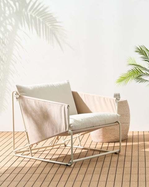 Gartenszene mit Sessel mit Metallrahmen und Stoffbezug