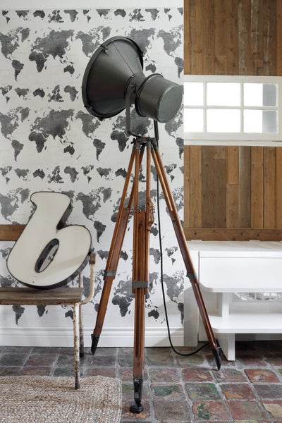 Innenraum mit Stehlampe auf Holzstativ und Weltkarten Tapete