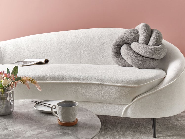 Szene mit Sofa, Kaffeetisch, Dekoration und Buch für die Raumgestaltung.