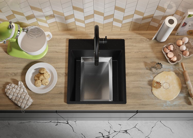 Küchenszene mit Spüle, Armatur, Küchenmaschine, Keksen, Eiern und Teig auf einer Arbeitsplatte.