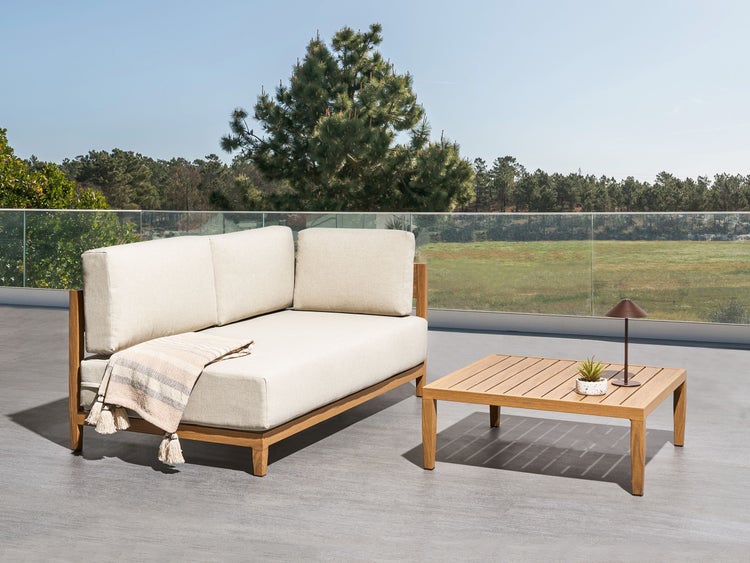 Gartenlounge-Set mit Couch, Tisch und Dekorationslampe auf einer Terrasse mit Ausblick