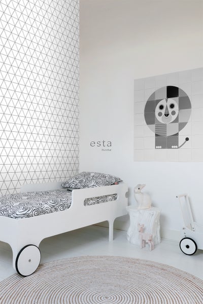 Kinderzimmer mit Bett, rundem Teppich und geometrischer Tapete