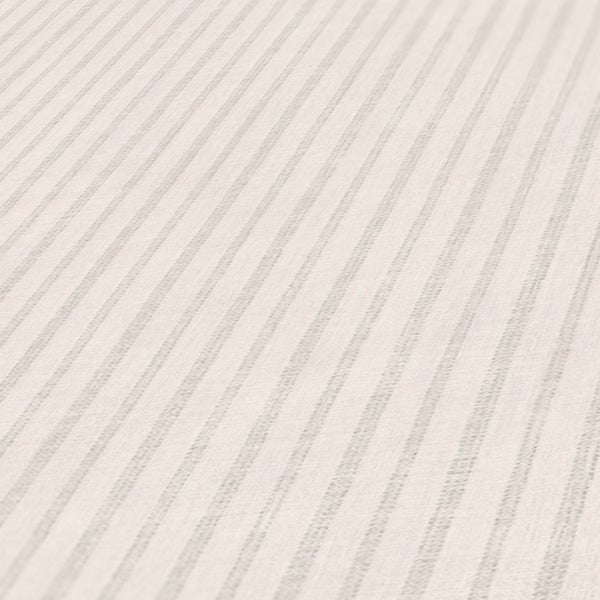 Nahaufnahme einer Kommode mit Zimmerpflanze, Büchern und gestreifter Tapete