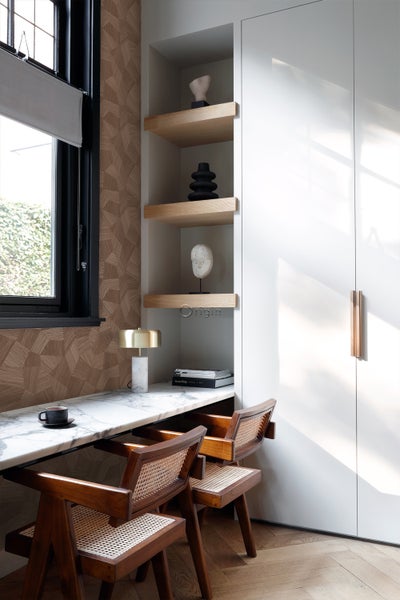 Arbeitszimmer mit Schreibtisch, Stühlen und Einbauschränken