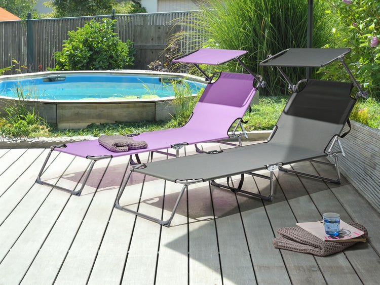 Szene mit Gartenliege, Beistelltisch, Dekoration und Pflanzen