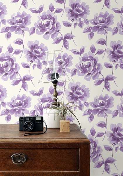 Szene mit Kommode, Tischlampe und Tapete mit Blumenmuster