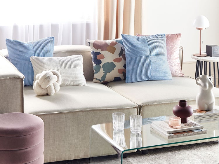 Wohnzimmer mit Sofa, Zierkissen, Couchtisch und dekorativen Accessoires für ein stilvolles Interieur