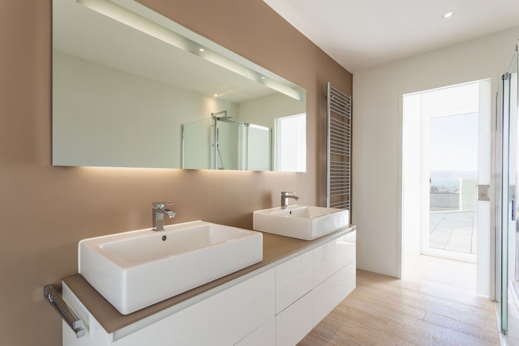 Badezimmer mit Doppelwaschtisch, großem Spiegel und Handtuchwärmer