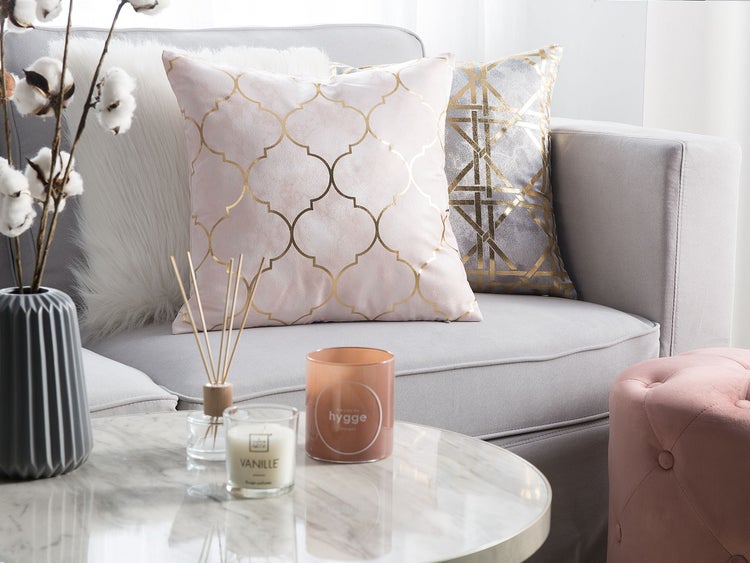 Dekorative Kissen auf Sofa mit Beistelltisch und Kerzen