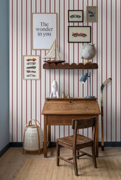 Vliestapete mit vertikalen Streifen in einem klassisch eingerichteten Kinderzimmer mit Holzschreibtisch und Dekoration.