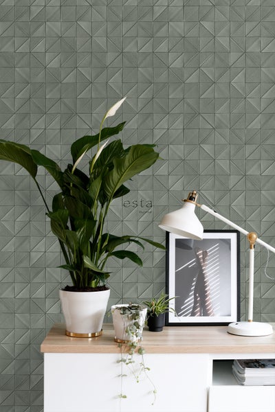Wandgestaltung mit dreieckigem Muster, Zimmerpflanzen und Tischleuchte auf einem Tisch