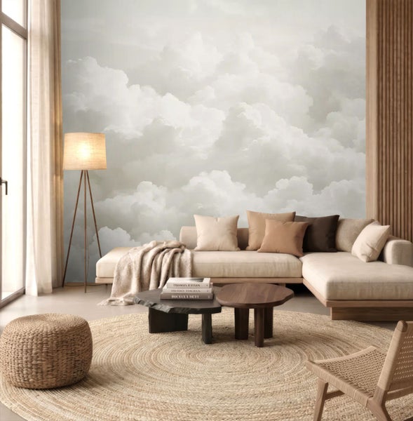 Modernes Wohnzimmer mit einer Fototapete im Wolken-Design, einem Ecksofa mit Kissen, Holz-Couchtischen und einem runden Jute-Teppich.
