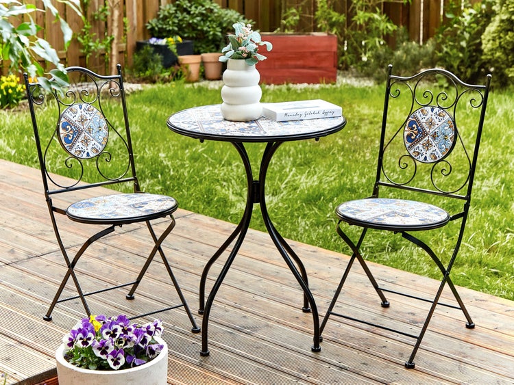 Gartentischgruppe mit zwei Stühlen mit Mosaikmuster auf einer Holzterrasse