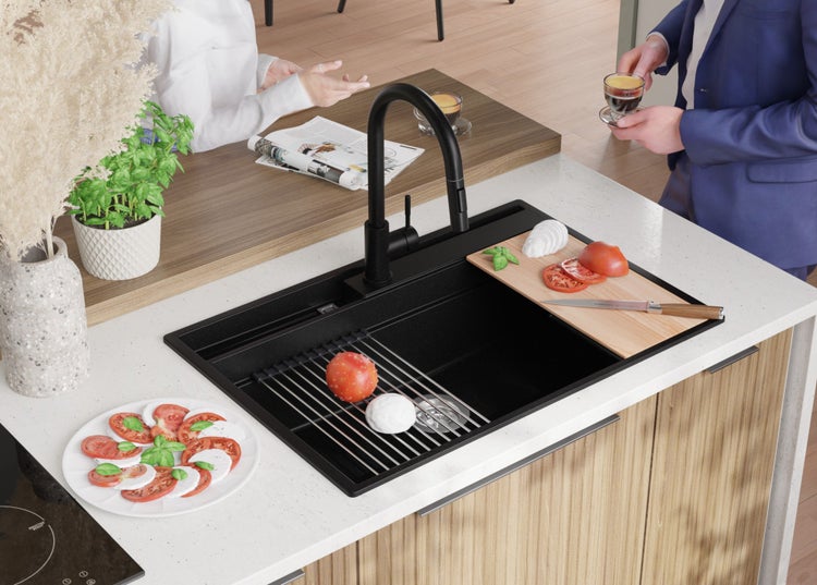 Schwarze Küchenspüle mit Schneidebrett und Abtropfgitter in einer modernen Küche.