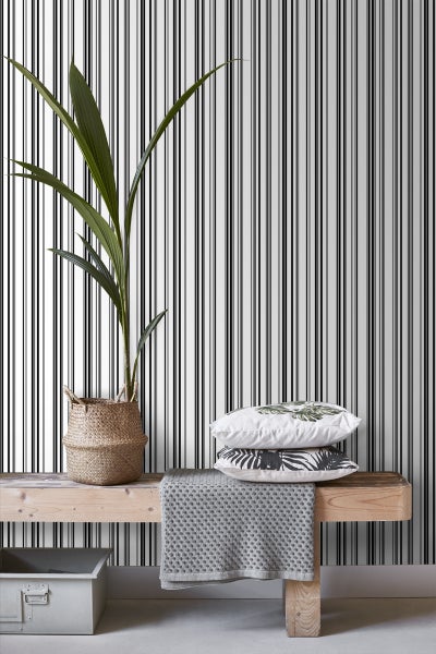 Dekoratives Zimmer mit gestreifter Tapete, Holzbank, Kissen und Zimmerpflanze