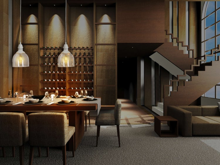 Innenaufnahme eines Esszimmers mit Esstisch, Stühlen, Weinregal und Treppe