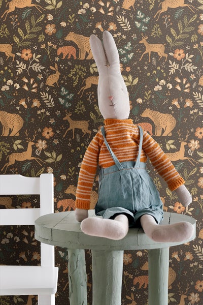 Dekoratives Kinderzimmer mit Stoffhase auf einem kleinen Tisch vor einer gemusterten Tapete