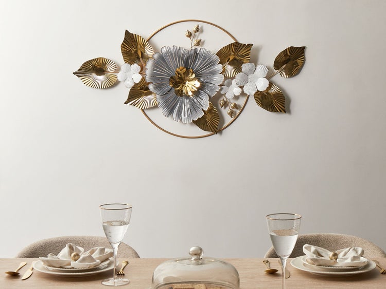 Wanddekoration aus Metall mit floralem Design über einem gedeckten Tisch