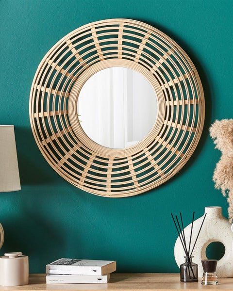 Runder Spiegel mit Rahmen aus Rattan an einer Wand
