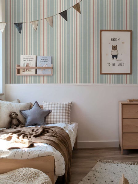 Kinderzimmer mit gestreifter Tapete, Holzmöbeln, Bilderrahmen mit Bärenmotiv und Wandregal mit Kinderbüchern.