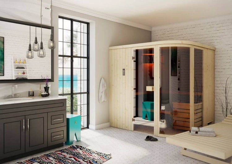 Modernes helles Badezimmer mit großer Holz-Innensauna mit Glasfront, dunklem Waschtisch und hölzerner Liege.