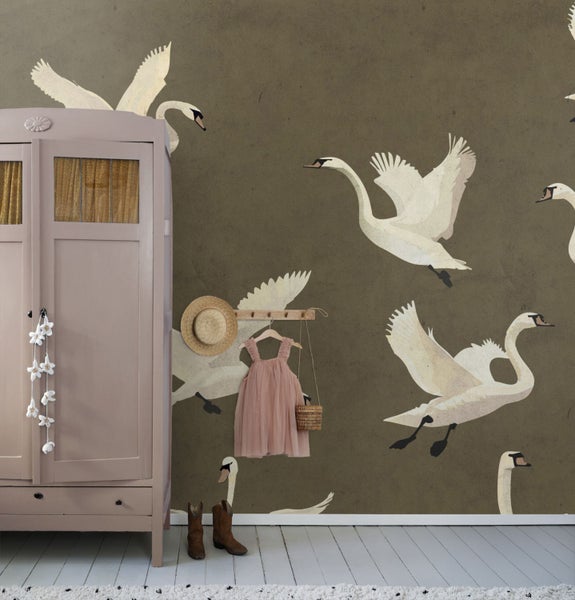 Kinderzimmer mit Schrank, Kleid, Hut und Tapete mit Schwanenmotiven.