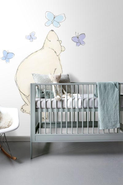 Kinderzimmer mit Babybett, Wandtattoo und Spielzeug