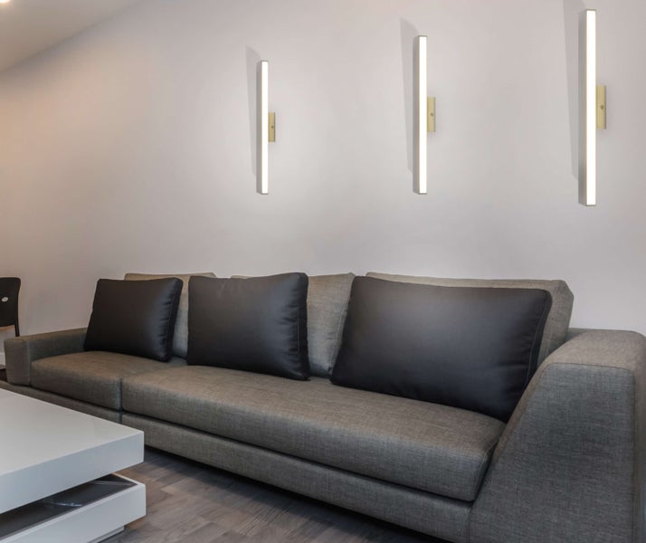 Wohnzimmer mit Sofa, Couchtisch und Wandleuchten