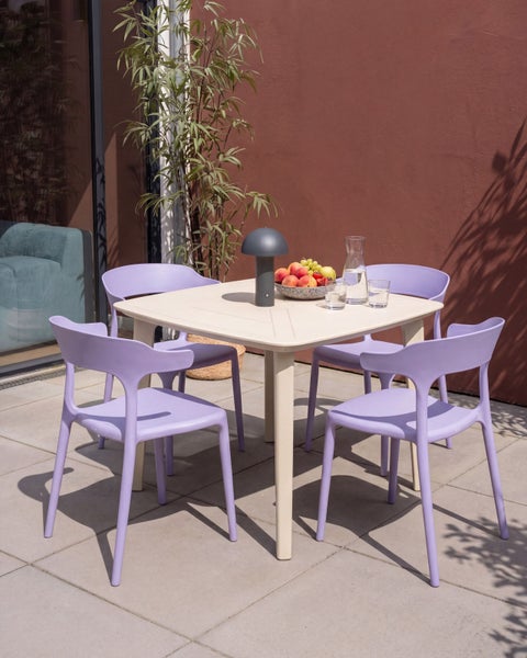 Moderne Garten-Sitzgruppe mit quadratischem Tisch und vier violetten Kunststoffstühlen auf einer hellen, gefliesten Terrasse.