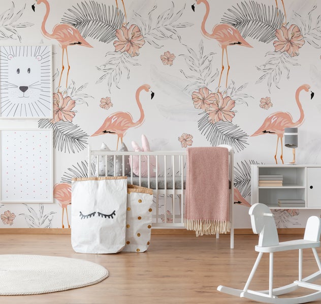 Vliesfototapete mit Flamingo-Motiv und tropischen Pflanzen in einem hell eingerichteten Babyzimmer mit Gitterbett und Schaukelpferd.