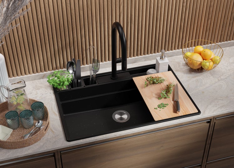 Küchenszene mit Spüle, Armatur, Schneidebrett, Kräutern und Küchenutensilien.