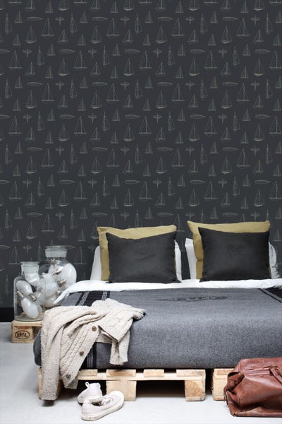 Maritime Tapete mit Segelboot-Muster in einem Schlafzimmer mit Palettenbett.