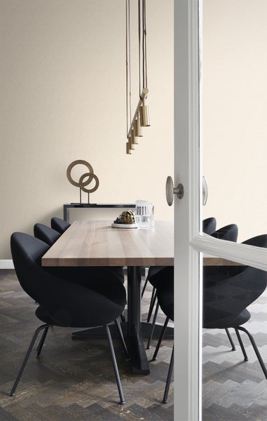 Heller Essbereich mit Holztisch, schwarzen Stühlen und dekorativer Beleuchtung