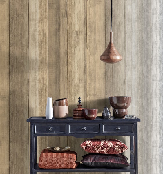 Zimmer mit floral gemusterter Tapete, Hocker, Kleiderhakenleiste mit Hut und Korb.