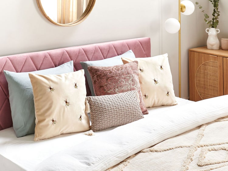 Dekoratives Schlafzimmer mit Kissen, Spiegel und Nachttisch